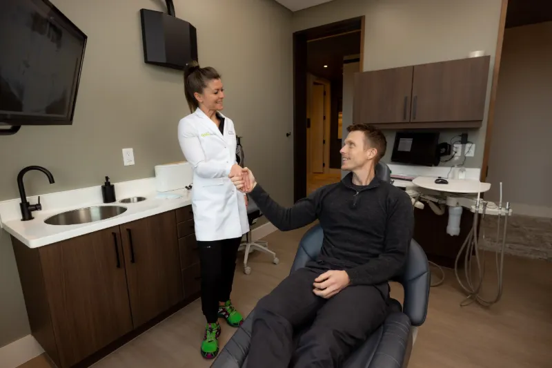 Dentist greeting a patient in the dental chair