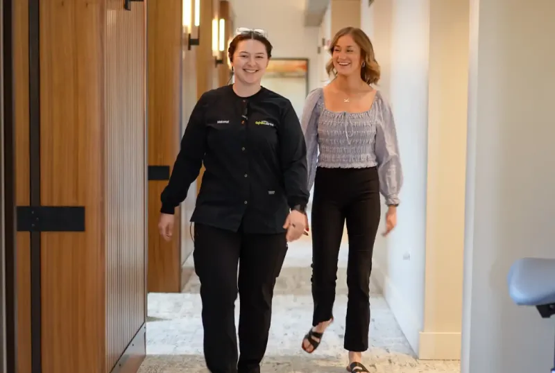 Team member walking with a patient down the hallway